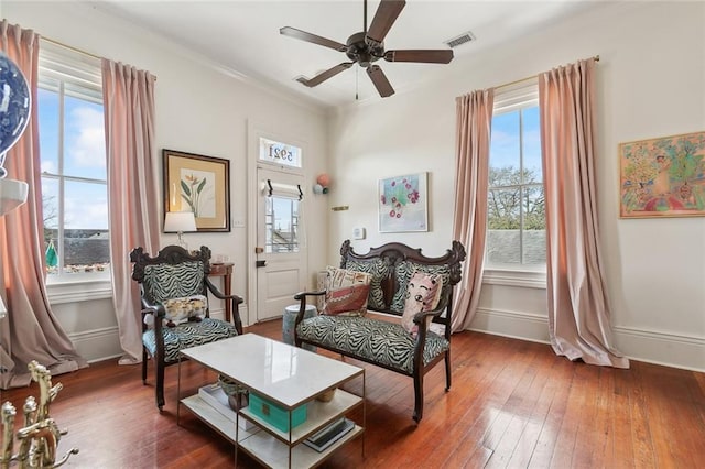 sitting room featuring a wealth of natural light, visible vents, and wood-type flooring