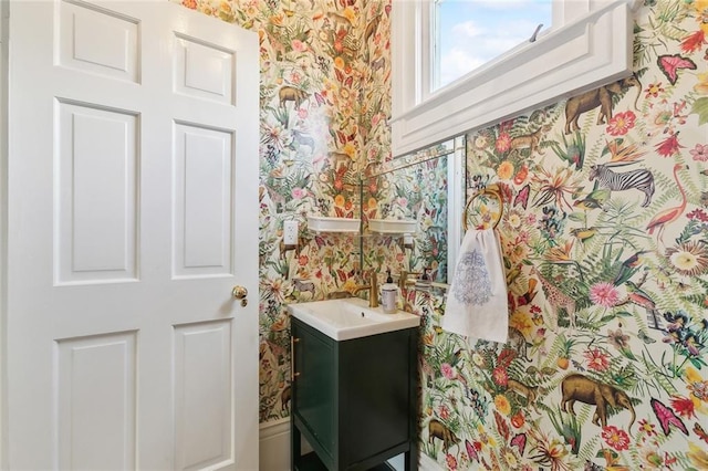 bathroom with wallpapered walls and vanity