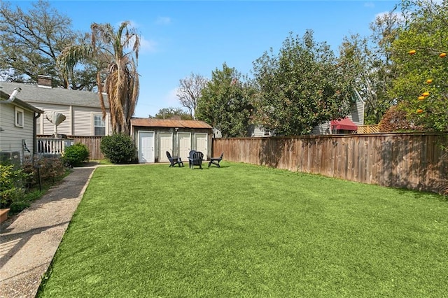 view of yard featuring an outbuilding, fence, and a shed