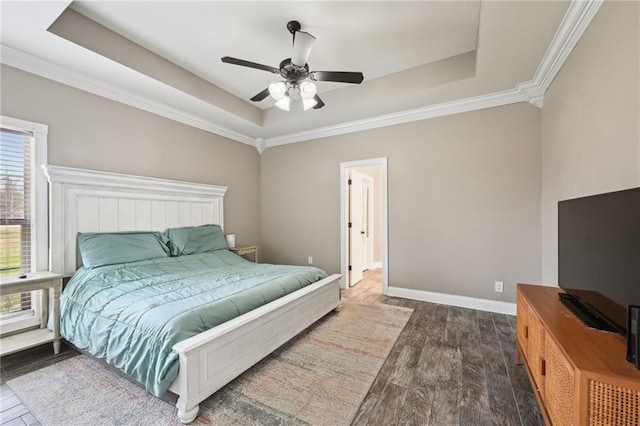 bedroom featuring baseboards, a tray ceiling, and wood finished floors