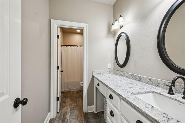 full bathroom featuring baseboards, toilet, a shower with curtain, wood finished floors, and vanity