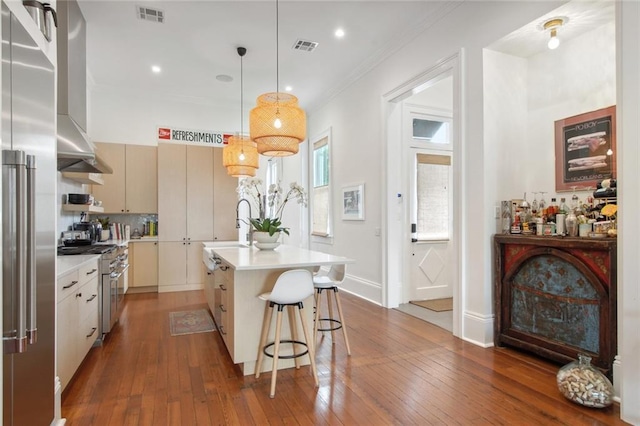 kitchen featuring premium appliances, ornamental molding, dark wood finished floors, and light countertops