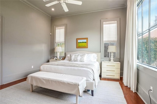 bedroom featuring dark wood finished floors, crown molding, and multiple windows