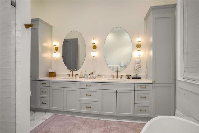 bathroom featuring double vanity, a soaking tub, marble finish floor, and a sink