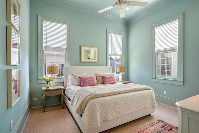 carpeted bedroom featuring ceiling fan, baseboards, multiple windows, and ornamental molding