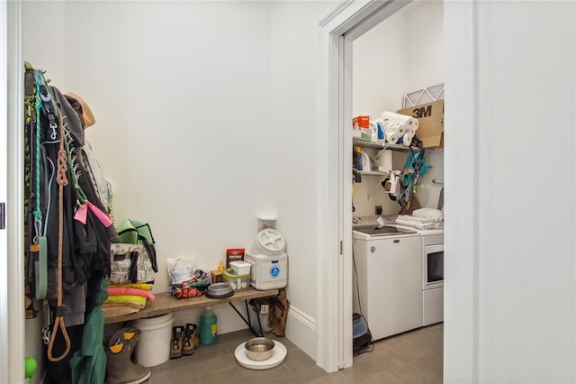 laundry room with baseboards, laundry area, and washer and clothes dryer