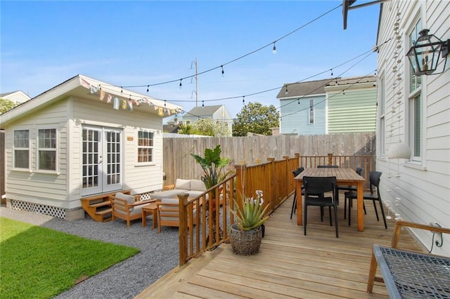 wooden terrace featuring fence, french doors, outdoor lounge area, an outdoor structure, and outdoor dining space