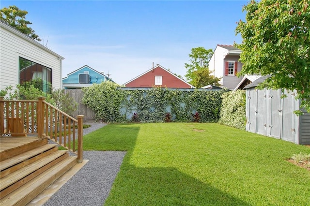 view of yard featuring an outbuilding, a fenced backyard, and a shed