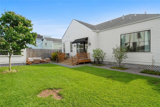 back of property with a yard, a deck, outdoor lounge area, and fence