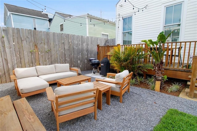 view of patio / terrace with a deck, an outdoor living space, and fence