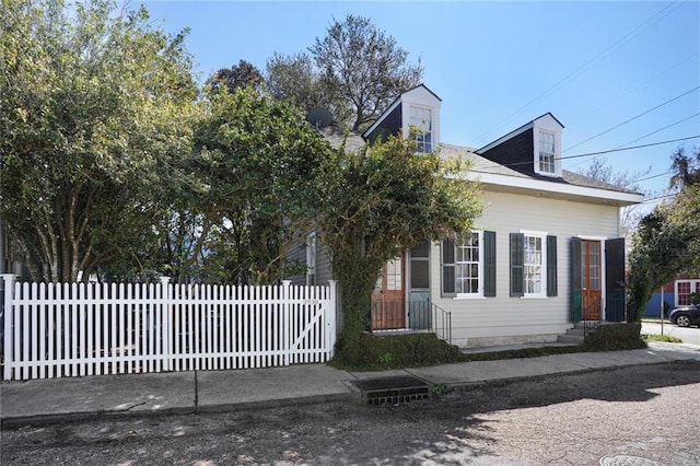 view of front facade featuring entry steps and a fenced front yard