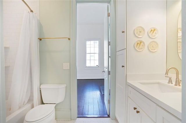 bathroom featuring baseboards, vanity, toilet, and shower / tub combo