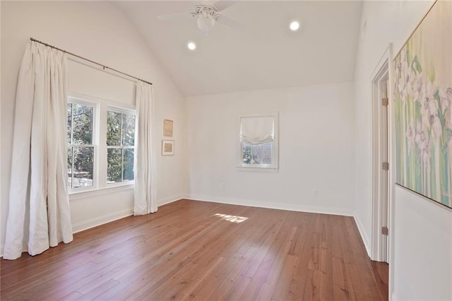 empty room featuring hardwood / wood-style floors, vaulted ceiling, recessed lighting, and baseboards