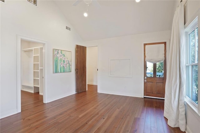 interior space featuring visible vents, baseboards, hardwood / wood-style floors, high vaulted ceiling, and a ceiling fan