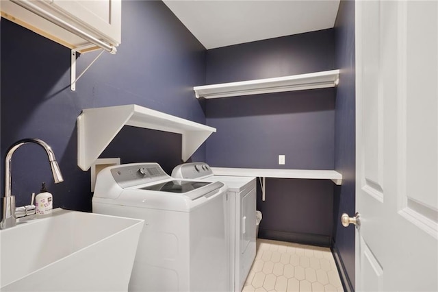 washroom with washing machine and clothes dryer, laundry area, light tile patterned floors, and a sink