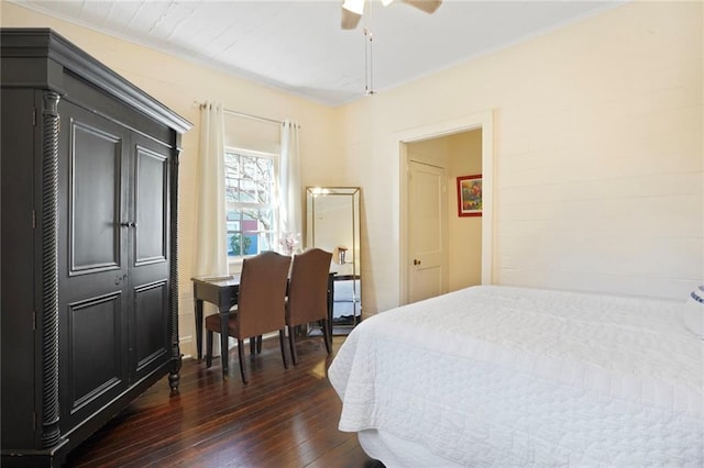 bedroom featuring dark wood-type flooring, a ceiling fan, and ornamental molding