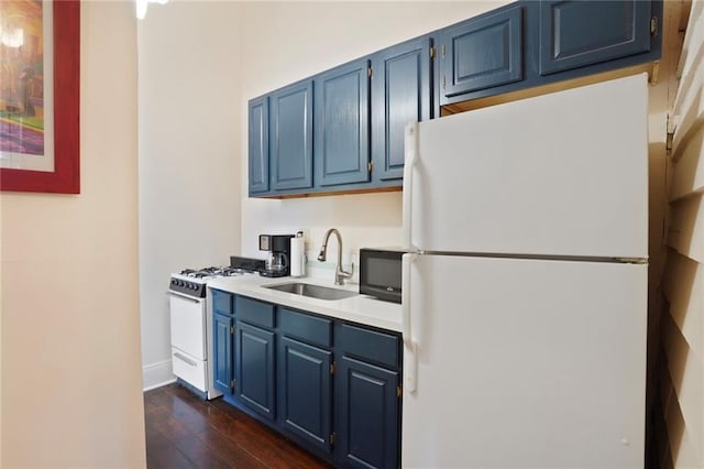 kitchen featuring white appliances, a sink, light countertops, dark wood-type flooring, and blue cabinets