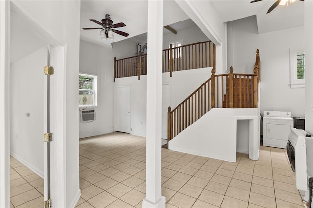 staircase featuring tile patterned floors, washer / dryer, a ceiling fan, and a wall unit AC