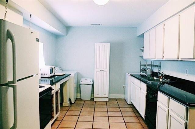 kitchen with visible vents, light tile patterned floors, white cabinets, white appliances, and a sink