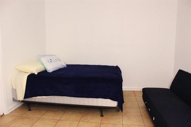 tiled bedroom featuring baseboards