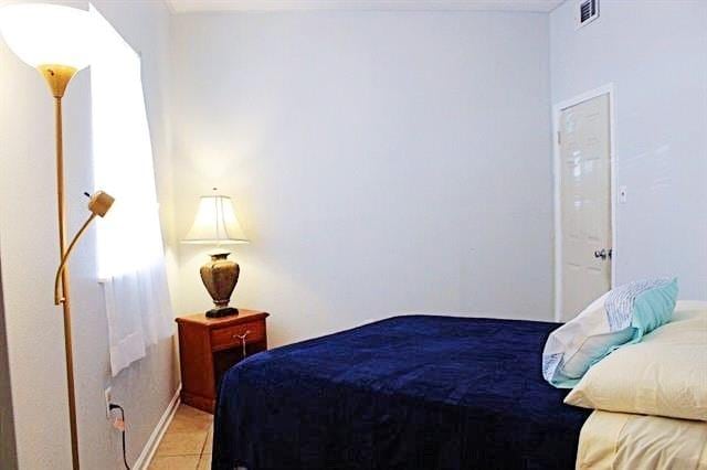 bedroom with light tile patterned floors and visible vents