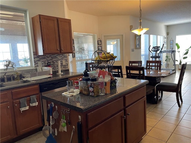 kitchen with light tile patterned floors, plenty of natural light, backsplash, and a sink