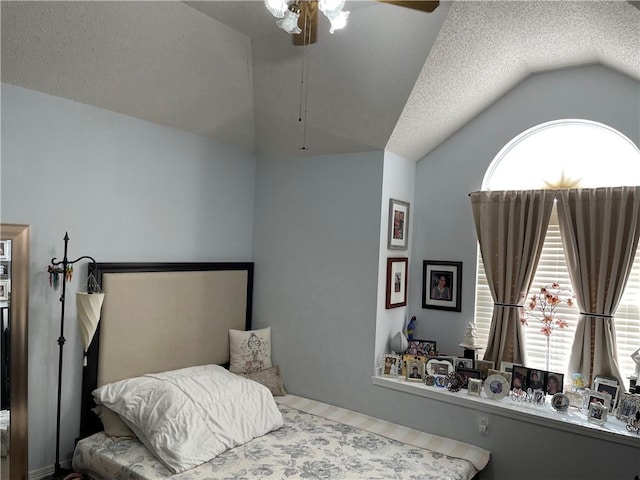 bedroom with lofted ceiling, a textured ceiling, and a ceiling fan