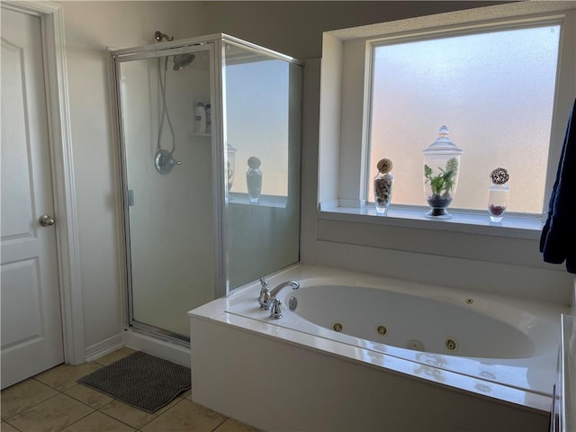 bathroom with tile patterned flooring, a jetted tub, a healthy amount of sunlight, and a stall shower