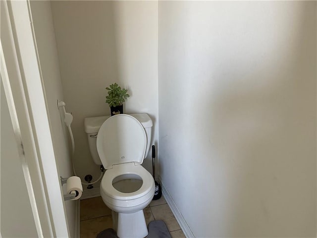 bathroom with tile patterned floors, toilet, and baseboards