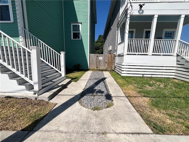 view of home's exterior with stairs, a gate, and covered porch