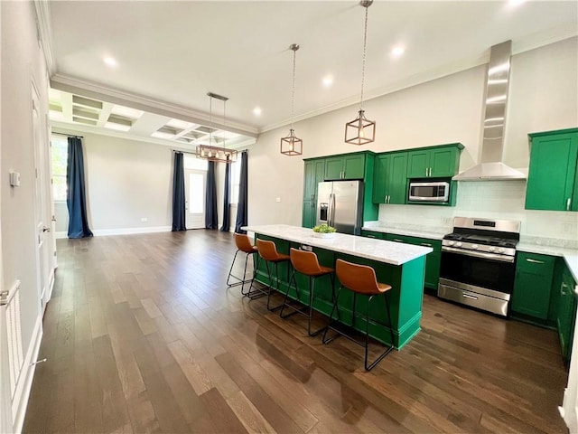kitchen featuring wall chimney range hood, green cabinetry, stainless steel appliances, and a kitchen breakfast bar