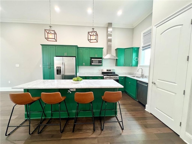 kitchen with a sink, green cabinetry, wall chimney range hood, and stainless steel appliances