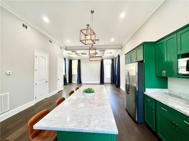 kitchen featuring green cabinetry, appliances with stainless steel finishes, a center island, visible vents, and ornamental molding
