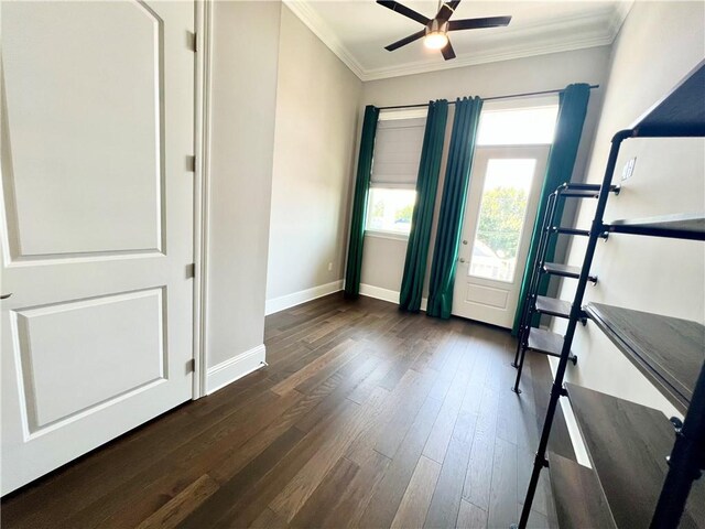 interior space with crown molding, baseboards, dark wood-type flooring, and ceiling fan