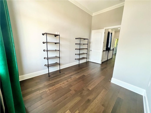 unfurnished room with crown molding, baseboards, and dark wood-style floors