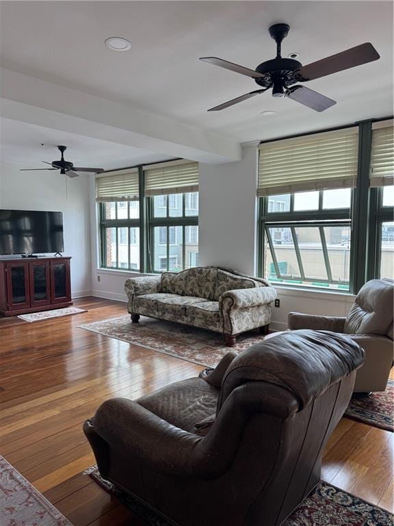 living room featuring baseboards, ceiling fan, and hardwood / wood-style flooring