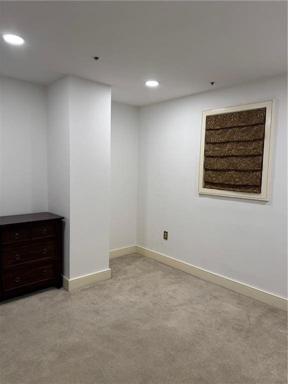 below grade area featuring recessed lighting, baseboards, and light carpet