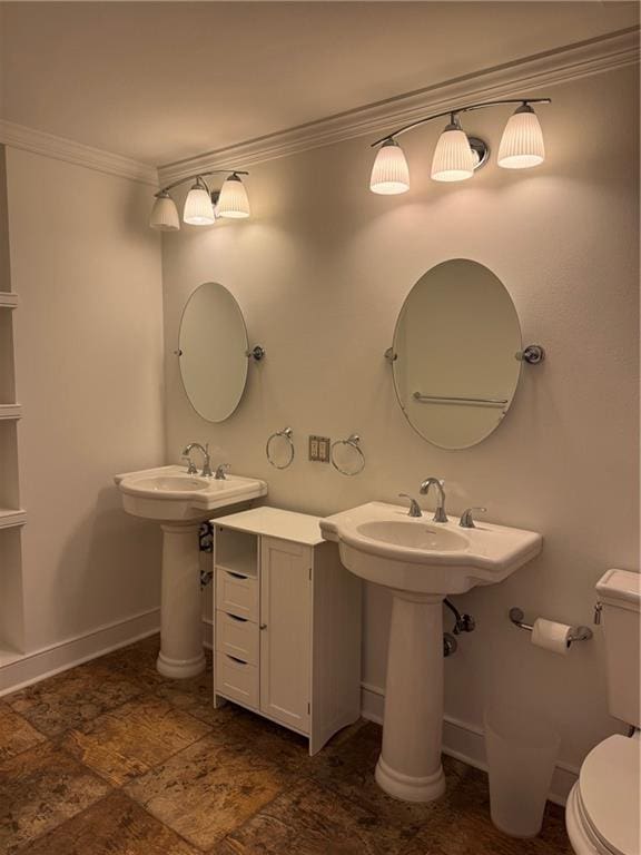 bathroom featuring baseboards, toilet, and crown molding