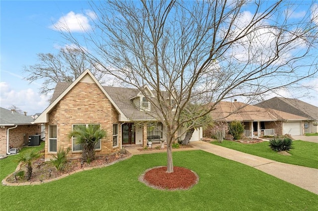 view of front of property featuring a garage, driveway, brick siding, and a front yard