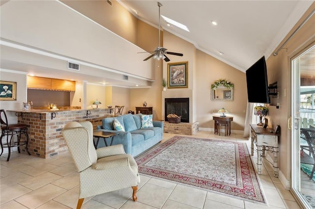 living area with light tile patterned flooring, visible vents, a fireplace, and ornamental molding