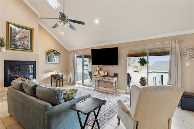 living area featuring high vaulted ceiling, light tile patterned flooring, ceiling fan, ornamental molding, and a glass covered fireplace