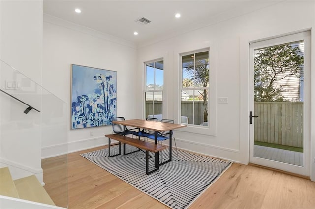 dining space featuring light wood-style flooring, a healthy amount of sunlight, and visible vents