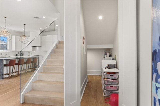 stairway featuring visible vents, recessed lighting, baseboards, and wood finished floors