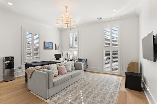 living area with visible vents, plenty of natural light, light wood-style flooring, and crown molding