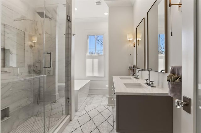 full bath with a sink, toilet, marble finish floor, and a stall shower