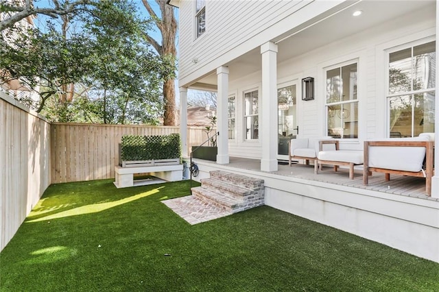 view of yard with a porch and a fenced backyard