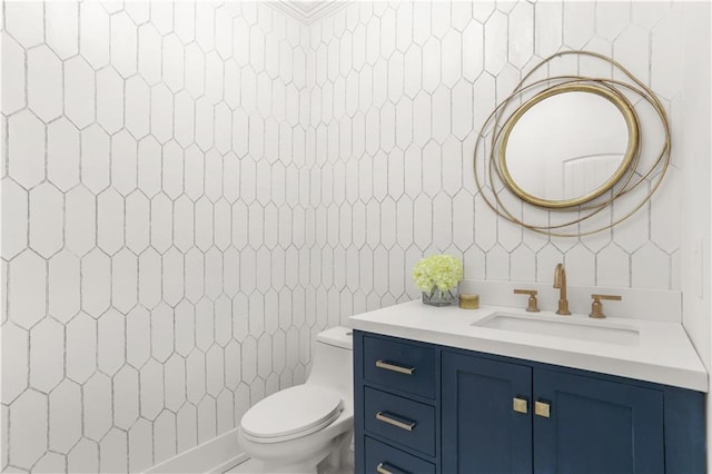 bathroom with toilet, tile walls, and vanity