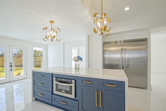 kitchen featuring french doors, stainless steel appliances, light countertops, and an inviting chandelier