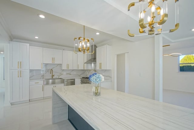 kitchen featuring backsplash, a chandelier, white cabinetry, wall chimney exhaust hood, and a sink