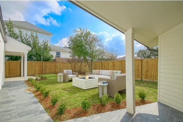 view of yard featuring a patio, an outdoor living space with a fire pit, and a fenced backyard